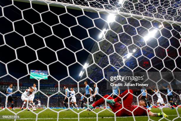 Fernando Muslera of Uruguay lies on the pitch dejected while Pepe of Portugal celebrates after scorig his side's first goal during the 2018 FIFA...