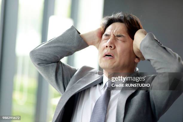 middle aged businessman suffering from headache - only mature men fotografías e imágenes de stock