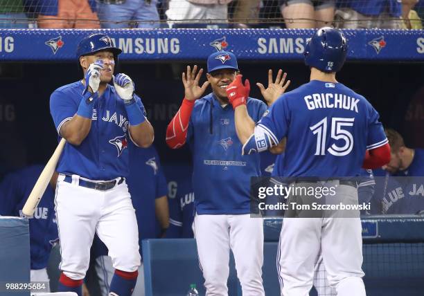 Randal Grichuk of the Toronto Blue Jays is congratulated by Yangervis Solarte and Marcus Stroman after hitting a two-run home run in the fifth inning...