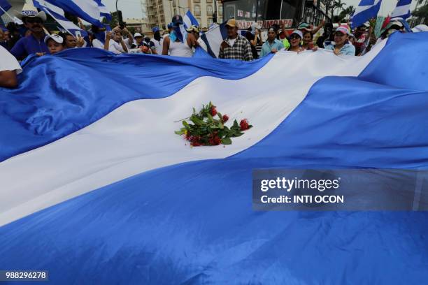 People attend the "Marcha de las Flores" -in honor of the children killed during protests- in Managua on June 30, 2018. - At least six people were...