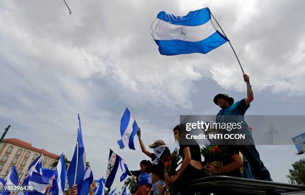 People attend the "Marcha de las Flores" -in honor of the children killed during protests- in Managua on June 30, 2018. - At least six people were...