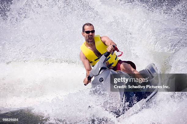 man on jet ski on lake - jet boat stock pictures, royalty-free photos & images