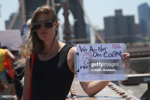 Demonstrator holds a sign as she marches from Foley Square to Brooklyn Bridge as part of "Keep Families Together" march to protest President Donald...