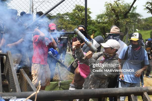 Anti-government protesters fire a homemade mortar during clashes within the "Marcha de las Flores" in Managua, on June 30, 2018. - At least six...