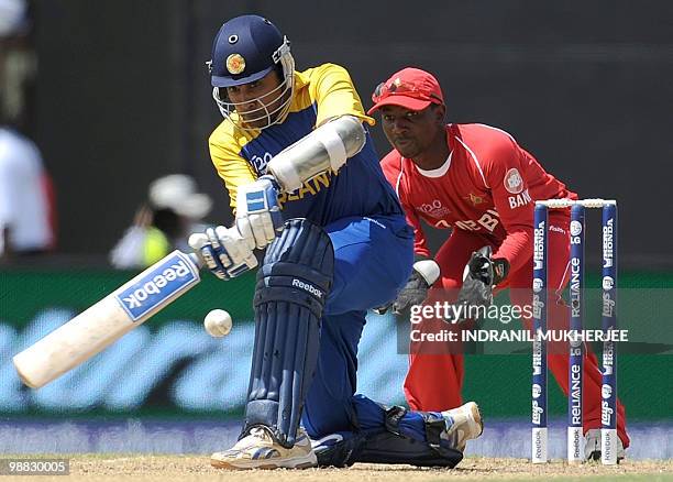 Sri Lankan cricketer Mahela Jayawardene plays a shot as Tatenda Taibu of Zimbabwe look on during their ICC T20 World Cup match at the Providence...