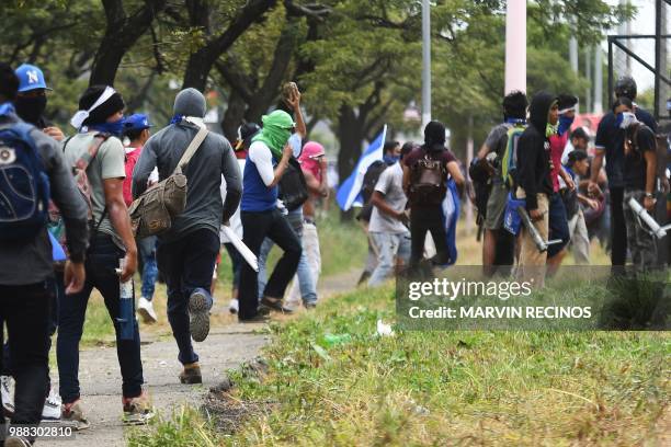 Anti-government protesters take part in clashes within the "Marcha de las Flores" in Managua, on June 30, 2018. - At least six people were shot and...