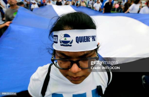 People attend the "Marcha de las Flores" -in honor of the children killed during protests- in Managua on June 30, 2018. - At least six people were...