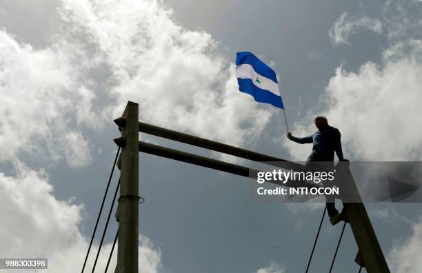 People attend the "Marcha de las Flores" -in honor of the children killed during protests- in Managua on June 30, 2018. - At least six people were...