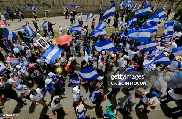 People attend the "Marcha de las Flores" -in honor of the children killed during protests- in Managua on June 30, 2018. - At least six people were...