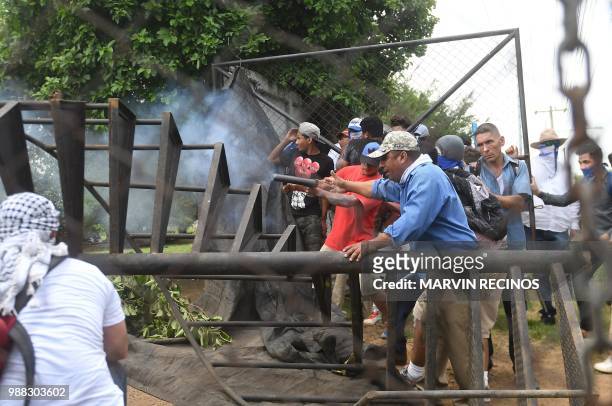 Anti-government protesters take part in clashes within the "Marcha de las Flores" in Managua, on June 30, 2018. - At least six people were shot and...