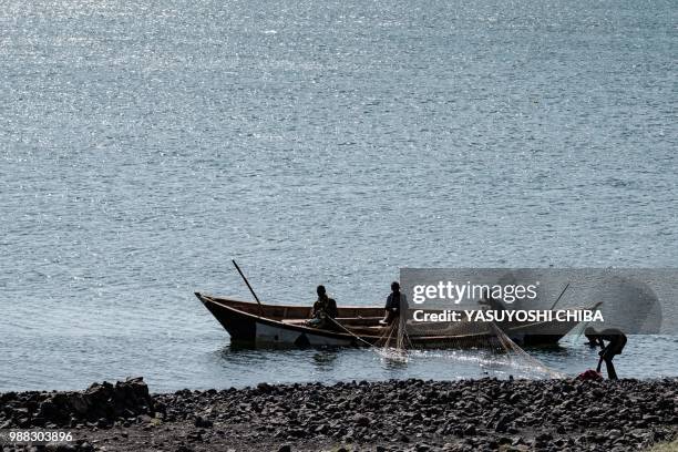 Local fishermen mend a casting net on Lake Turkana, the world's largest desert lake, in northern Kenya, on June 30, 2018. - A UNESCO panel added Lake...