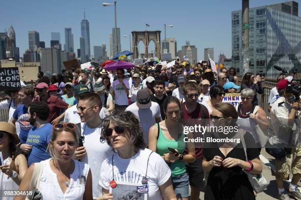 Demonstrators march across the Brooklyn Bridge during a protest against the Trump administration's policy on separating immigrant families in the...