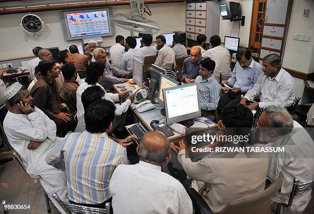 Pakistani stock dealers work at a brokerage house during a trading session in Karachi on May 4, 2010. The benchmark Karachi Stock Exchange 100 index...