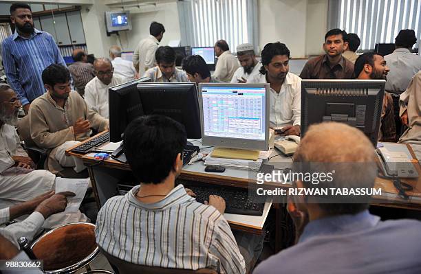 Pakistani stock dealers work at a brokerage house during a trading session in Karachi on May 4, 2010. The benchmark Karachi Stock Exchange 100 index...