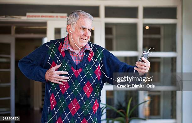 elderly man listening to music with headphones - newfamily stock pictures, royalty-free photos & images