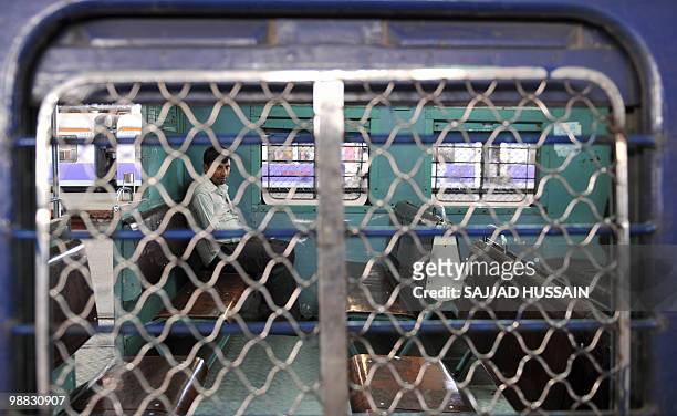Commuter sits inside a train compartment waiting for train services to resume at the Chhrapati Shivaji Terminus in Mumbai on May 4, 2010. Striking...