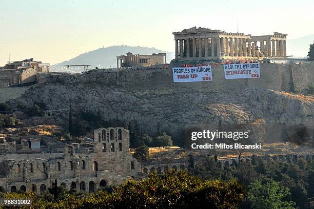 Members of Communist Party of Greece wave flags from the Acropolis Hill, and display large banners from the front Parthenon Temple on May 4, 2010 in...