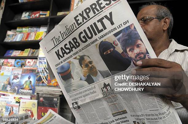 An Indian man reads a newspaper carrying a front-page story of convicted 2008 Mumbai attacks gunman Mohammed Ajmal Amir Kasab in Kolkata on May 4,...