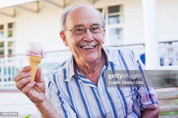 elderly man eating an ice cream - newfamily stock pictures, royalty-free photos & images