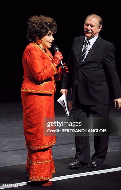 Italian actress Gina Lollobrigida speaks to the audience as French actor Pierre Santini looks on during a ceremony in hommage to French legend actor...
