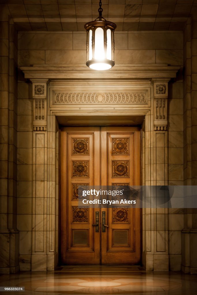 Ornate neoclassical door in marble wall