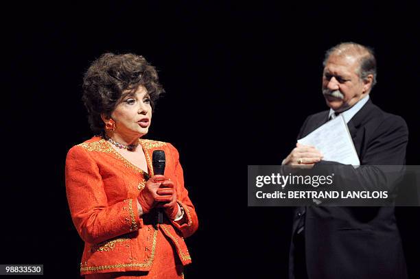 Italian actress Gina Lollobrigida speaks to the audience as French actor Pierre Santini looks on during a ceremony in hommage to French legend actor...