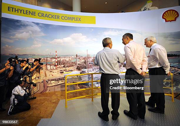 Peter Voser, chief executive officer of Royal Dutch Shell Plc, right, stands with Lee Hsien Loong, Singapore's prime minister, center, as they view a...