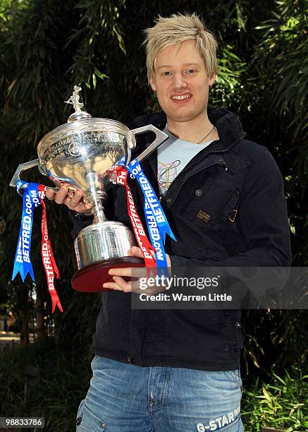 Neil Robertson of Australia poses with the trophy at a photocall after beating Graeme Dott of Scotland to win the Betfred.com World Snooker...