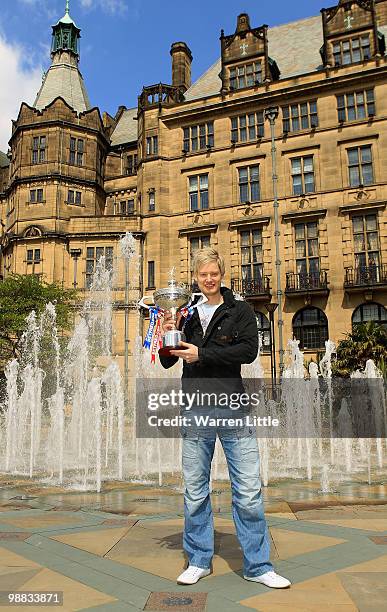 Neil Robertson of Australia poses with the trophy at a photocall after beating Graeme Dott of Scotland to win the Betfred.com World Snooker...