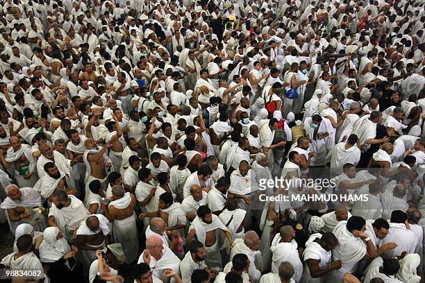 Muslim pilgrims throw pebbles at pillars during the "Jamarat" ritual, the stoning of Satan, in Mina near the holy city of Mecca on November 27, 2009....