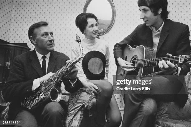 Pete Townshend of The Who pictured playing an acoustic guitar with his father Cliff Townshend , saxophone player with the Squadronaires, and mother...