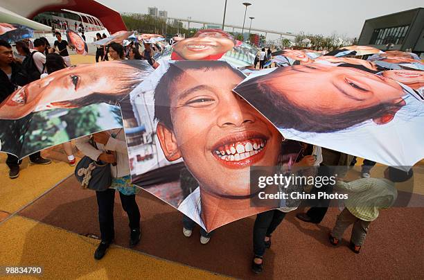 Tourists hold the 'Smile Face Umbrellas' at the Japan Pavilion during the 2010 World Expo on May 4, 2010 in Shanghai, China. The World Expo will be...