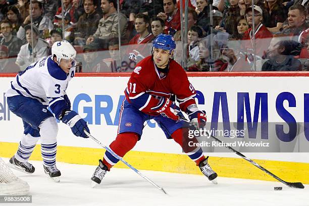 Scott Gomez of the Montreal Canadiens skates with the puck while being defended by Dion Phaneuf of the Toronto Maple Leafs during the NHL game on...