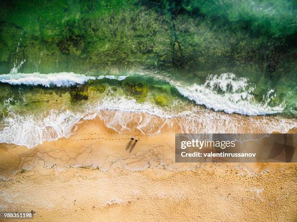 high angle view of couple standing on the beach - people aerial view beach stock pictures, royalty-free photos & images