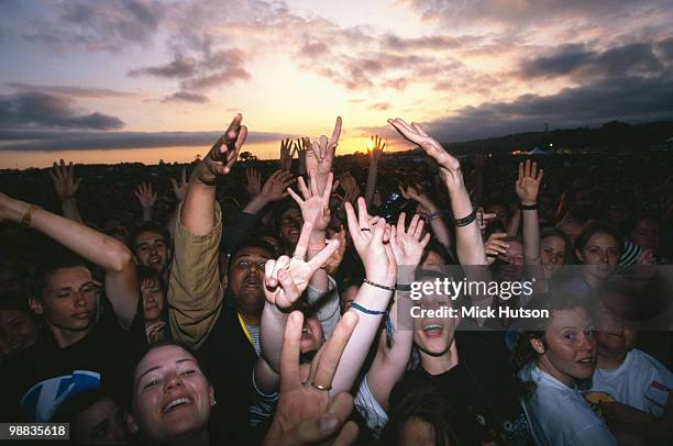 The audience with hands in the air at sunset at the Glastonbury Festival in June 1994.