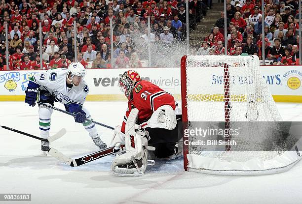 Michael Grabner of the Vancouver Canucks chases the puck toward goalie Antti Niemi of the Chicago Blackhawks at Game One of the Western Conference...