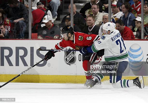 Mason Raymond of the Vancouver Canucks reaches across Jordan Hendry of the Chicago Blackhawks at Game One of the Western Conference Semifinals during...