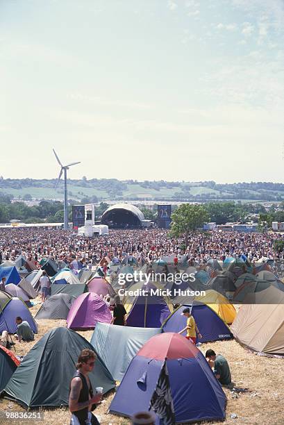 The Glastonbury Festival in June 1995, showing tents, main stage and wind turbine.