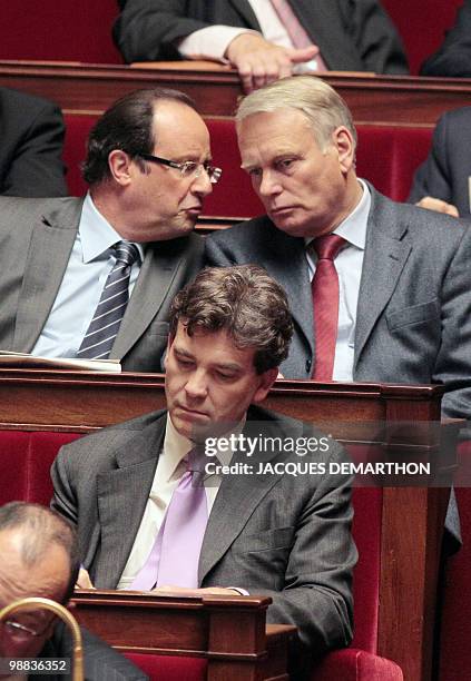 French socialist deputy Francois Hollande speaks with shakes hands with head of French PS group at the national Assembly Jean-Marc Ayrault as they...