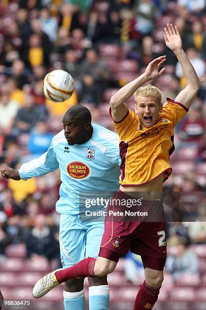 Adebayo Akinfenwa of Northampton Town heads the ball under pressure from Robbie Threlfall of Bradford City during the Coca Cola League Two Match...