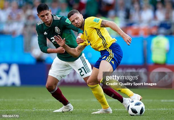 Marcus Berg of Sweden is challenged by Edson Alvarez of Mexico during the 2018 FIFA World Cup Russia group F match between Mexico and Sweden at...