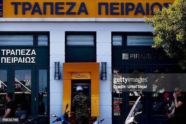 Greek soldier stands in front of a cash machine on May 4, 2010 in Mytilene, Greece. Independent travel agency Sunvil has stated that Greek tourism...