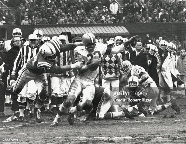 Jim Brown of the Cleveland Browns carries the ball against Billy Ray Smith Sr. #74 of the Baltimore Colts as Bobby Boyd and Monte Clark look on...
