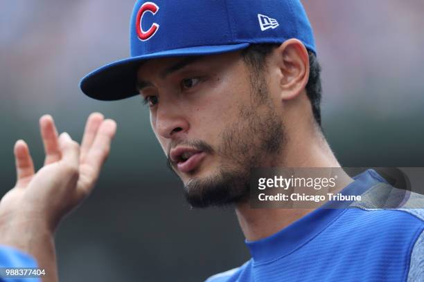 Chicago Cubs pitcher Yu Darvish talks with a team trainer while watching a game against the Minnesota Twins in the third inning at Wrigley Field in...
