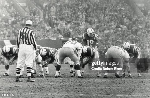 Johnny Unitas of the Baltimore Colts stands under center Buzz Nutter as Sam Huff of the New York Giants lines up to defend during the 1959 NFL...