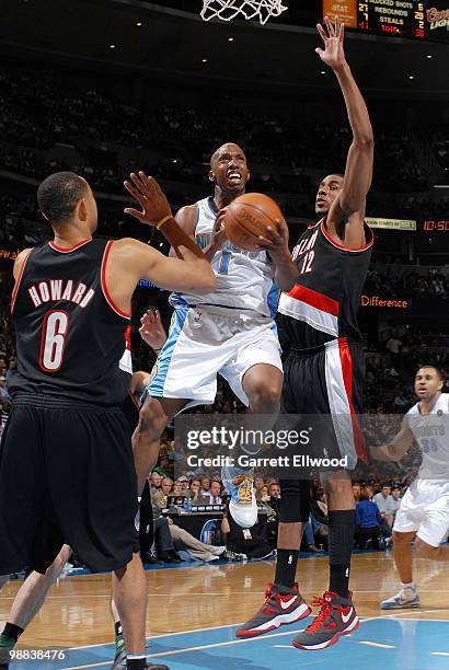 Chauncey Billups of the Denver Nuggets takes the ball to the basket against Juwan Howard and LaMarcus Aldridge of the Portland Trail Blazers during...
