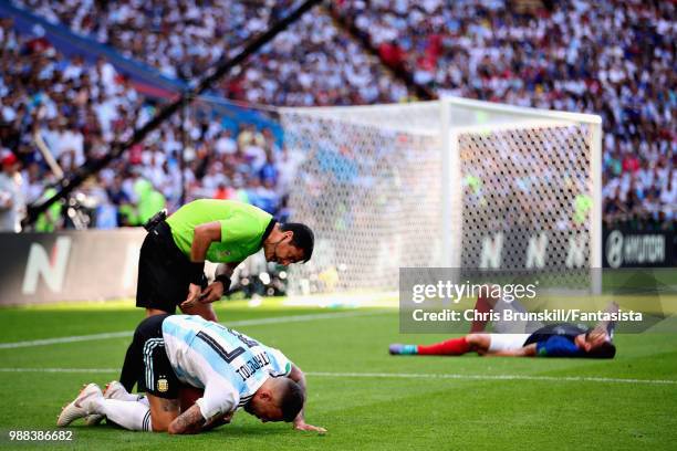 Referee Alireza Faghani checks on Nicolas Otamendi of Argentina as Olivier Giroud of France lies injured during the 2018 FIFA World Cup Russia Round...