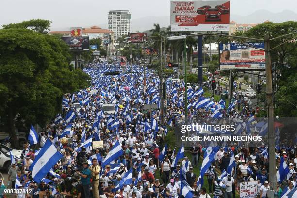 People attend the "Marcha de las Flores" -in honor of the children killed during protests- in Managua on June 30, 2018. - At least six people were...