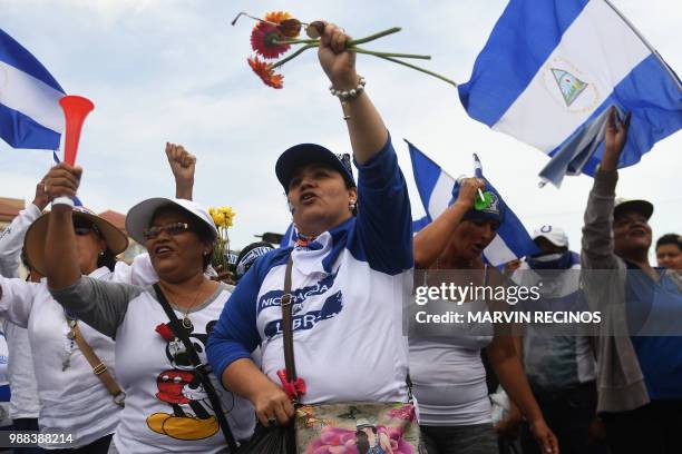 People attend the "Marcha de las Flores" -in honor of the children killed during protests- in Managua on June 30, 2018. - At least six people were...