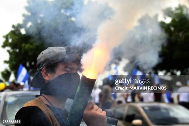 Man fires a homemade mortar during clashes within the "Marcha de las Flores" -in honor of the children killed during protests- in Managua on June 30,...